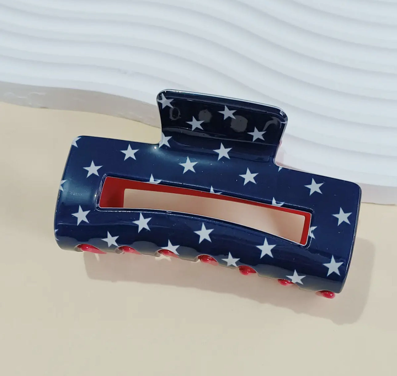 The Mama X™ Brand Red White and Blue/Star Claw Clip features a navy base with white stars and red dots, offering patriotic flair and a strong hold for any hairstyle.