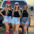 Three women in cowboy boots, denim shorts, black tanks, and Mama X™ Brand&