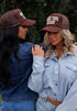 Two women wear "Bless your heart" hats from Mama X™ Brand.