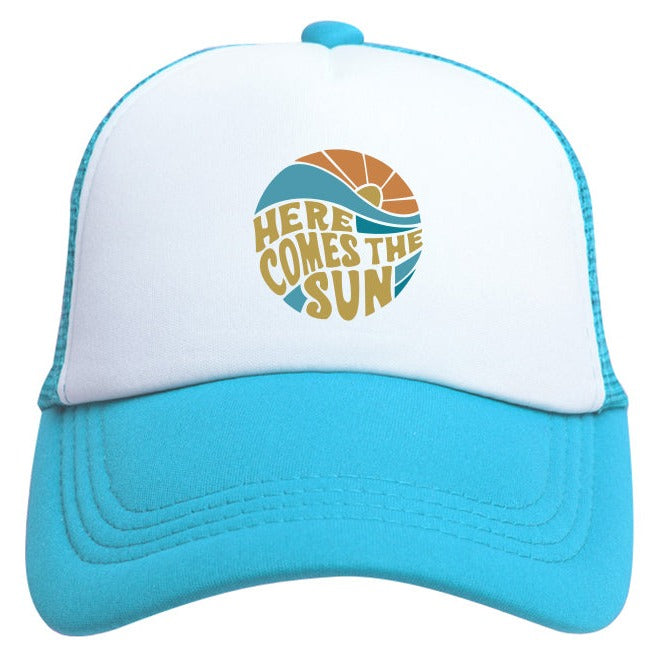 The Here Comes The Sun Trucker Hat by Mama X™ Brand is a stylish blue and white 5-panel cap featuring the phrase "Here Comes the Sun" in a circular design on the front. The design showcases a sun and wave motif in vibrant shades of orange and blue, making it an ideal summer activity hat. It also comes with an adjustable snap for added comfort.