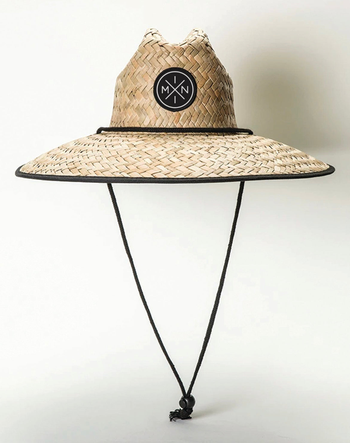 The Mini X Lifeguard Hat - Toddler/Youth from Mama X™ Brand features a wide-brimmed straw design with a black logo patch on the front and a black adjustable chin strap. Ideal for excellent sun protection, it's perfect as a kids' summer hat. The brim and crown are accented with a thin black band against a plain white background.