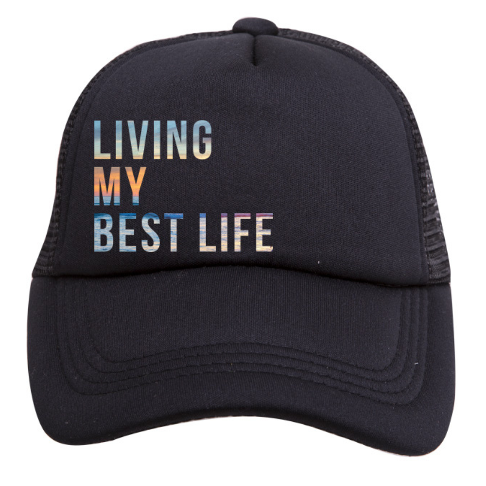 Introducing the *Living My Best Life Trucker Hat* by *Mama X™ Brand*. This black trucker hat features a mesh back and a front panel adorned with the vibrant text "LIVING MY BEST LIFE." The gradient colors seamlessly transition from light blue to pink and orange, combining both style and sun protection.