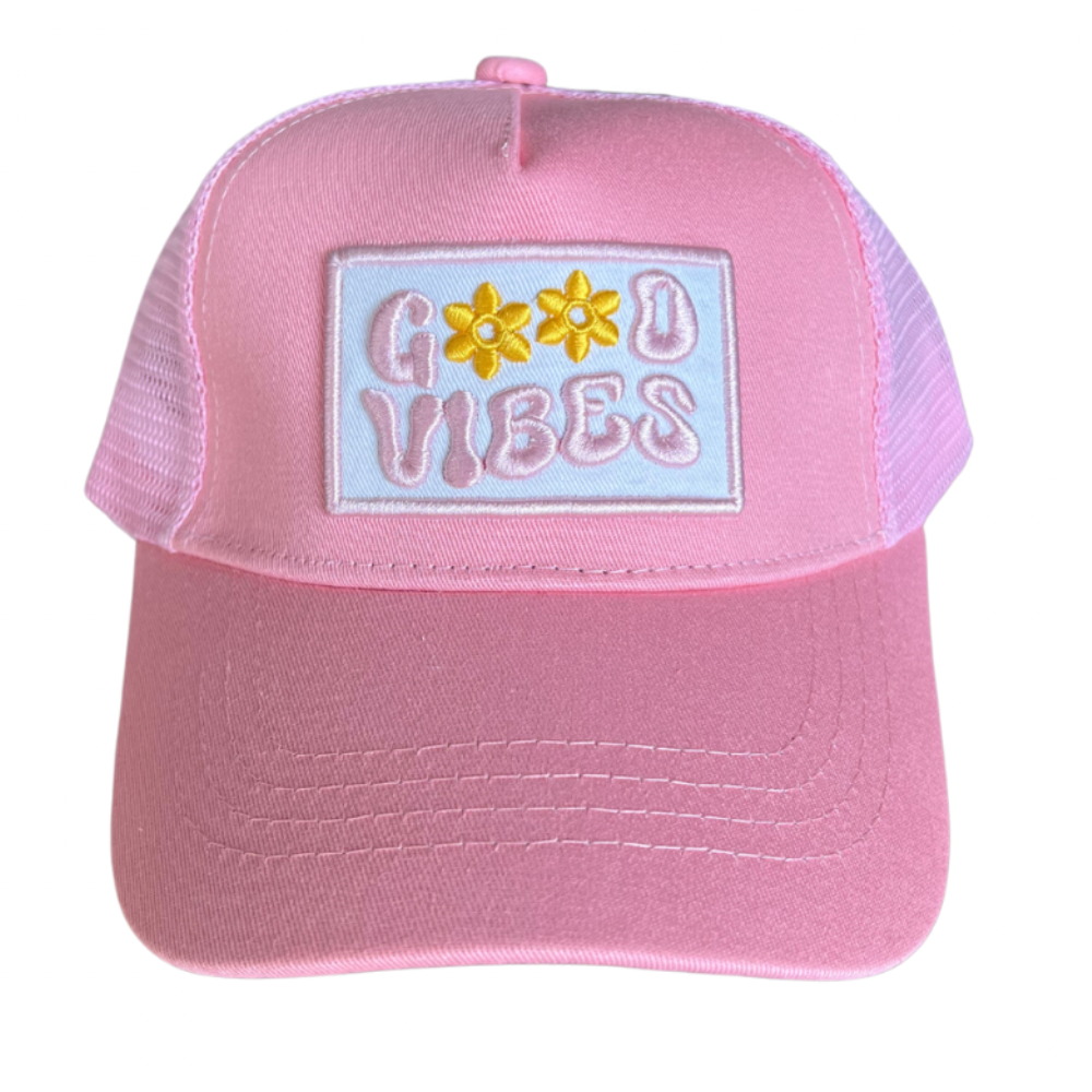 The Good Vibes Trucker Hat by Mama X™ Brand is an adorable pink 5-panel cap that displays "GOOD VIBES" in colorful, playful letters with two yellow flower icons replacing the O&