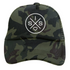 The Sis X Trucker Hat by Mama X™ Brand features a green camouflage design with a prominent SIS X logo on the front panel. The unique logo showcases two intersecting lines forming an "X," with the letters "S" and "H" at the top and bottom, and a heart symbol in the lower right quadrant. Crafted from durable Polyester/Nylon Mesh.