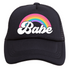 The Rainbow Babe Trucker Hat from Mama X™ Brand is a black 5-panel cap featuring the word "Babe" in white, stylized cursive letters. Above the text, there&